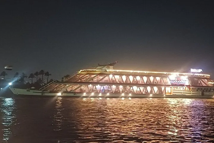 View of the Nile River in Egypt with calm waters reflecting the sky and boats sailing along the riverbanks